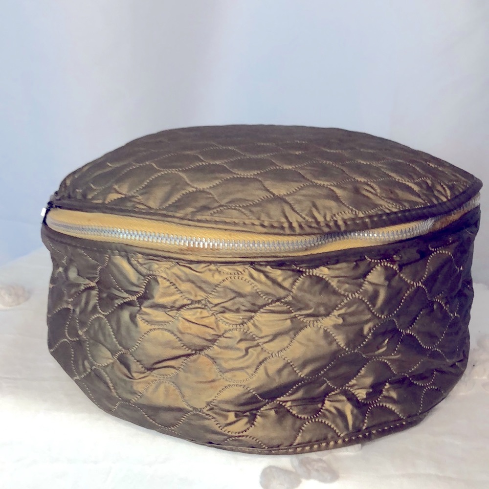 Bronze colored cosmetic set of 3 bags. Quilted pattern of round cosmetic cases.